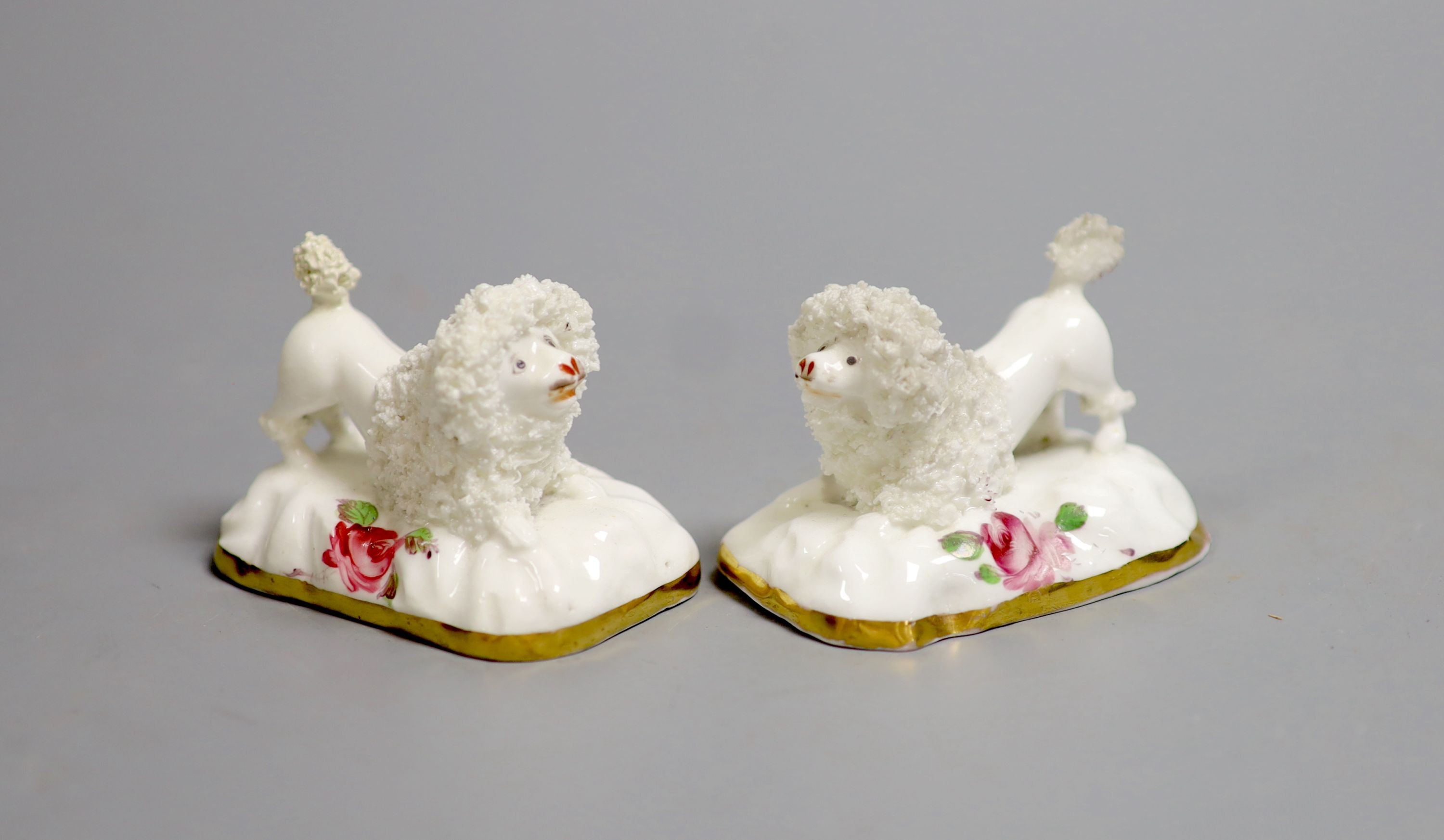 A pair of Staffordshire porcelain models of begging poodles, c.1830-50, each on a pink rose painted base, 6.8 cm long